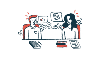 Two people are seen having a discussion during a meeting, with notebooks and papers on the table in front of them.
